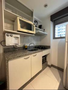 a small kitchen with a microwave and a sink at Premium Copacabana - Rio de Janeiro in Rio de Janeiro