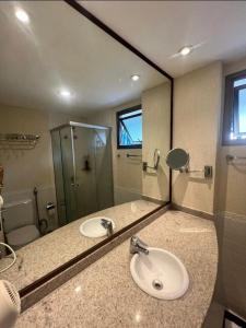 a bathroom with a sink and a shower and a mirror at Premium Copacabana - Rio de Janeiro in Rio de Janeiro