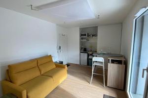 a living room with a couch and a kitchen at joli studio in Chens-sur-Léman