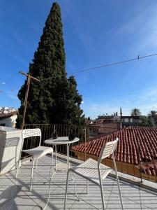 eine Terrasse mit 2 Stühlen, einem Tisch und einem Baum in der Unterkunft Erkal Pension in Antalya