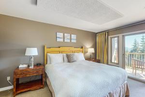 1 dormitorio con 1 cama grande y balcón en Cascade Bay Getaway en Eastsound