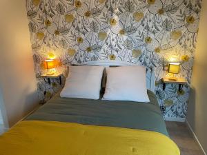 een slaapkamer met een bed met 2 kussens en 2 lampen bij La Paulerie 