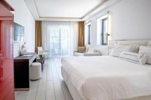 una camera bianca con un grande letto e un soggiorno di Diamond Deluxe Hotel - Adults Only a Città di Kos