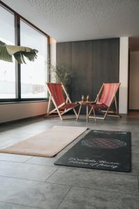 a living room with two chairs and a table at Hotel Wochtla Buam in Brunico