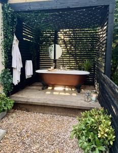 a bathroom with a bath tub on a wooden deck at Peterswell Holiday Cottage in Houston
