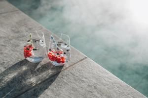 two glasses with strawberries in them sitting on a table at Hotel Wochtla Buam in Brunico