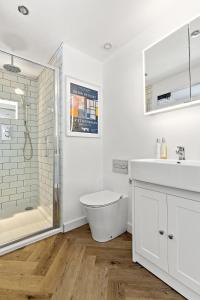 a bathroom with a toilet and a sink and a shower at Peterswell Holiday Cottage in Houston