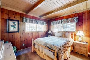 a bedroom with a bed in a room with wooden walls at Mountain Memories in Shaver Lake