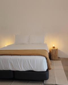 a bedroom with a large bed with white sheets at Casa Alquerque in Monsaraz +17 photos