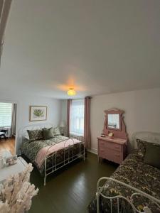 - une chambre avec un lit, un miroir et un canapé dans l'établissement Hôtel Le Rustique, à Saint-Irénée
