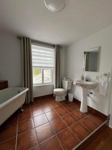 łazienka z wanną, toaletą i umywalką w obiekcie Hôtel Le Rustique w mieście Saint-Irénée