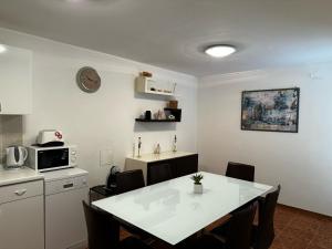 a kitchen with a table with chairs and a microwave at Apartments Casa Mia in Dramalj