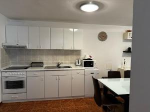 a kitchen with white cabinets and a sink at Apartments Casa Mia in Dramalj
