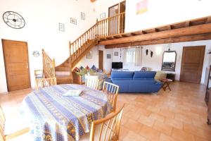 a living room with a table and a blue couch at pretty detached villa with private swimming pool, in Aureille, in the alpilles - 8 people in Aureille
