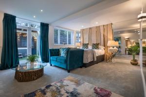 a bedroom with a bed and a blue couch at Aphrodites Group - Luxury Hot Tub Suites in Central Lake District! in Bowness-on-Windermere +266 photos