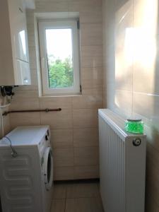 ein kleines Badezimmer mit Waschmaschine und Fenster in der Unterkunft Zielony Dom - Przystań Kajakowa Zakole in Krasnopol + 24 Fotos
