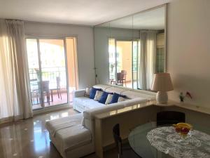 uma sala de estar com um sofá e uma mesa em Elegant Monaco Port de Fontvieille apartment with Garden View and Pool Access em Monte Carlo