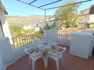 a table and chairs on the balcony of a house at Casa Margarita in Bubión