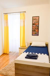 a bedroom with a bed with yellow curtains at Charming marine style apartment in Cres