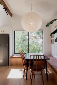 ein Esszimmer mit Tisch und Stühlen und einem großen Fenster in der Unterkunft Trendy apartment in the heart of West Hobart in Hobart