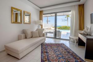 a living room with a white couch and a view of the ocean at Diamond Deluxe Hotel - Adults Only in Kos Town