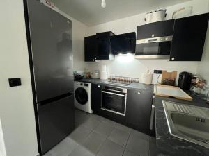 a kitchen with a refrigerator and a dishwasher at Superbe T2, Paris, Stade de France, WIFI, Parking in Saint-Denis +9 photos