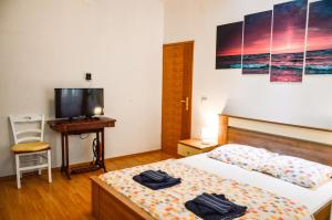 a bedroom with a bed and a desk and a television at Charming marine style apartment in Cres