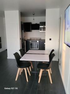 a kitchen with a table and chairs in a room at Superbe T2, Paris, Stade de France, WIFI, Parking in Saint-Denis