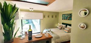 Habitación con cama y mesa con botella de vino en Apt Barrio Histórico 3 min Metro, Wifi, Netflik, Comodidad, en Santiago