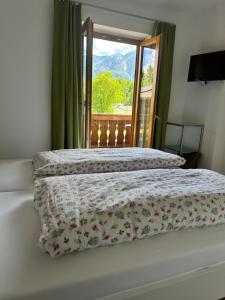 a bed with a floral comforter and a window at Ferienwohnungen Quellenhof in Bad Reichenhall