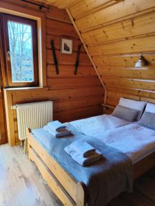 Chata u Wozniaka في كوشتيليسكا: غرفة نوم بسريرين في منزل خشبي