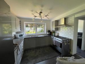 Brampton Grange的住宿－Beautiful 3 Double Bedroom Home-Cambridge Village Location，厨房配有水槽和炉灶 顶部烤箱