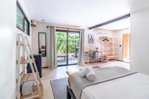 a bedroom with a bed and a room with a desk at Believe Surf & Yoga Lodge Santa Teresa in Santa Teresa Beach