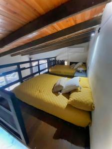 2 letti in una camera con lenzuola e cuscini gialli di Casa los Abuelos a Xalapa
