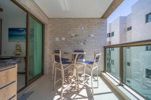 uma cozinha com uma mesa e cadeiras numa varanda em Apartamento Ninho das Gaivotas - Praia dos Anjos Residence - 2 Vagas em Arraial do Cabo
