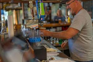 a man is making a drink in a blender at Geneva Hotel & Tiki Bar in Lake Lure
