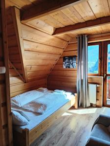 Chata u Wozniaka في كوشتيليسكا: غرفة نوم بسرير في منزل خشبي