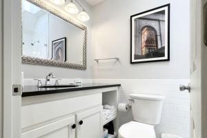 een badkamer met een wastafel, een toilet en een spiegel bij Newbury Guest House in Boston