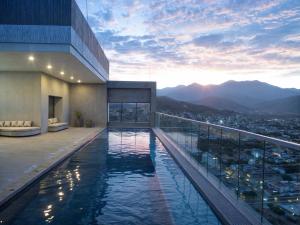 a hotel swimming pool with a view of a city at Rodadero- Ámbar Deluxe in Santa Marta