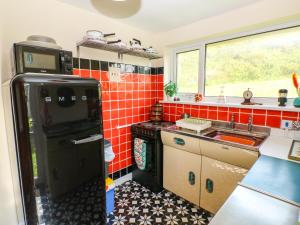 a small kitchen with a stove and a sink at Jasper's Corner in Kingsbridge