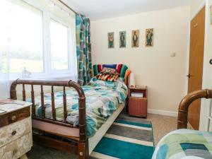 a bedroom with a crib and a bed and a window at Jasper's Corner in Kingsbridge
