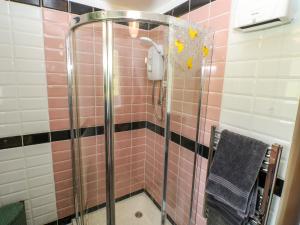 a bathroom with a shower with pink and black tiles at Jasper's Corner in Kingsbridge +21 photos