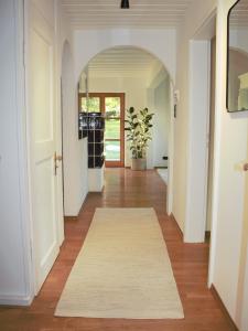 un corridoio con arco e tappeto bianco di Ferienhaus Flying Roots Wackersberg a Wackersberg