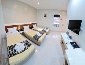 pokój hotelowy z 2 łóżkami i telewizorem w obiekcie Antonio's Inn w Calbayog