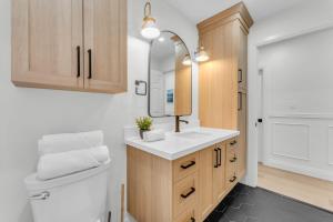 W łazience znajduje się umywalka, toaleta i lustro. w obiekcie Luxury Family Home in Burlington w mieście Burlington