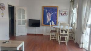 ein Wohnzimmer mit einem Tisch und Stühlen sowie einem TV in der Unterkunft UMBRIA Mar in Punta Umbría