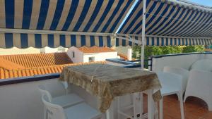 einen Tisch und Stühle auf einem Balkon mit Sonnenschirm in der Unterkunft UMBRIA Mar in Punta Umbría