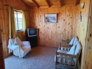 uma sala de estar com um sofá e uma televisão em Cabañas algarrobo em Algarrobo