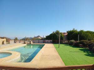 uma piscina num quintal com um relvado verde em Cabañas algarrobo em Algarrobo