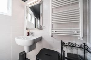 a white bathroom with a sink and a mirror at Apartament Belvedere Ławica Airport in Poznań